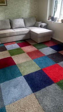 Een prachtige mix van hoogpolige tapijttegels in vrolijke kleuren, ideaal voor een gezellige en huiselijke sfeer.